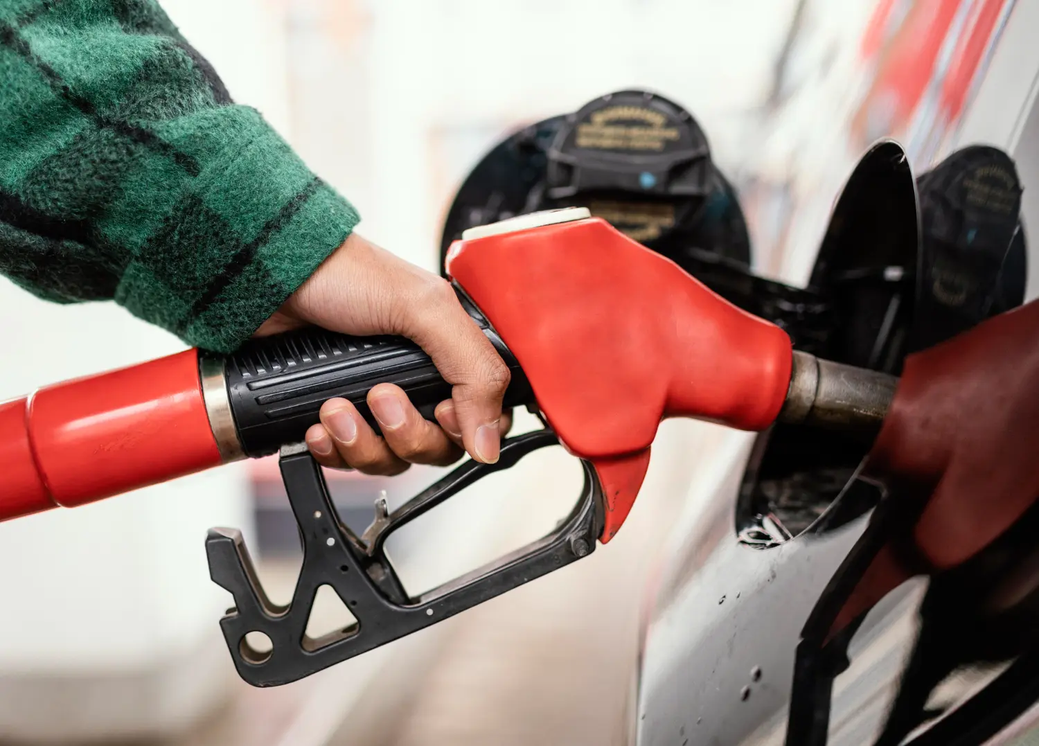 Homem utilizando uma bomba para posto de gasolina